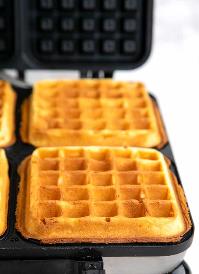 Two browned square waffles in waffle iron