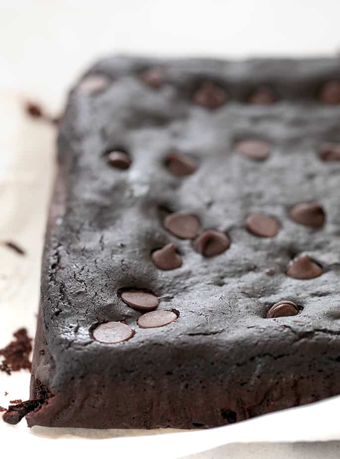 Black bean brownies out of pan uncut on white paper