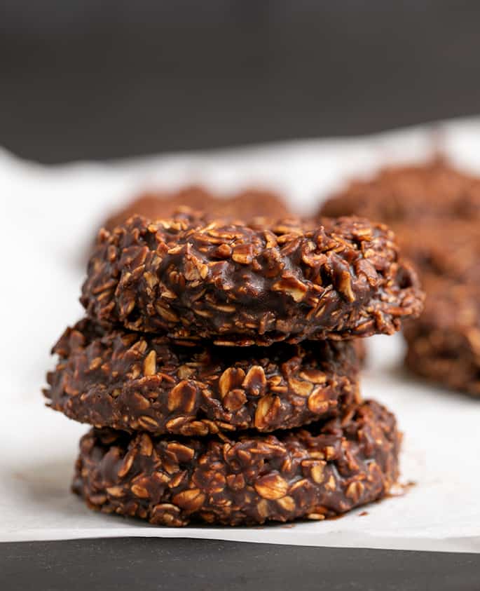 Stack of 3 chocolate oat cookies on white paper