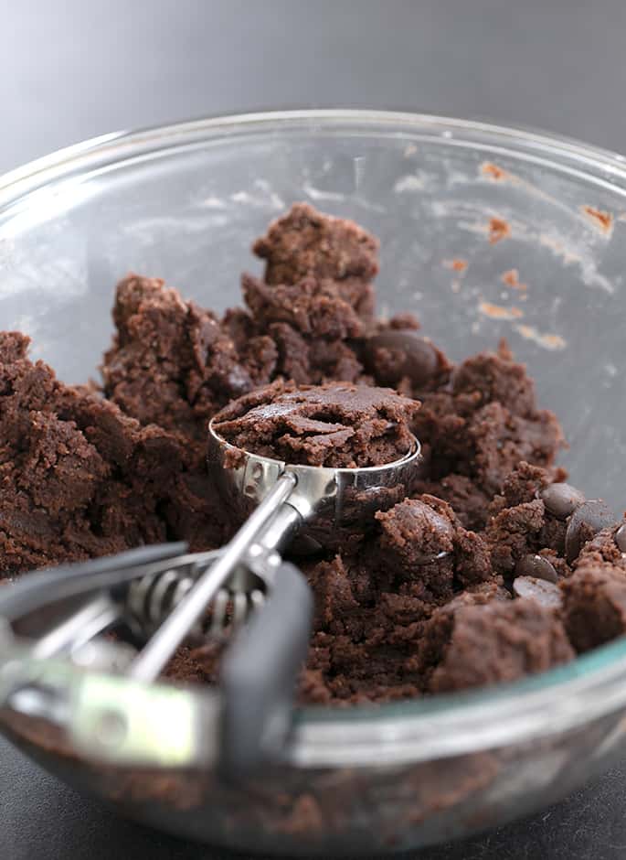 Chocolate cookie dough in a bowl with a scoop