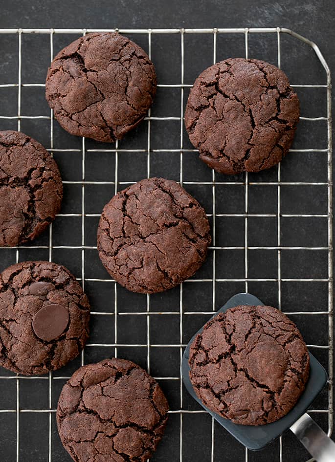 gluten free chocolate cookies overhead image on a wire rack with a spatula