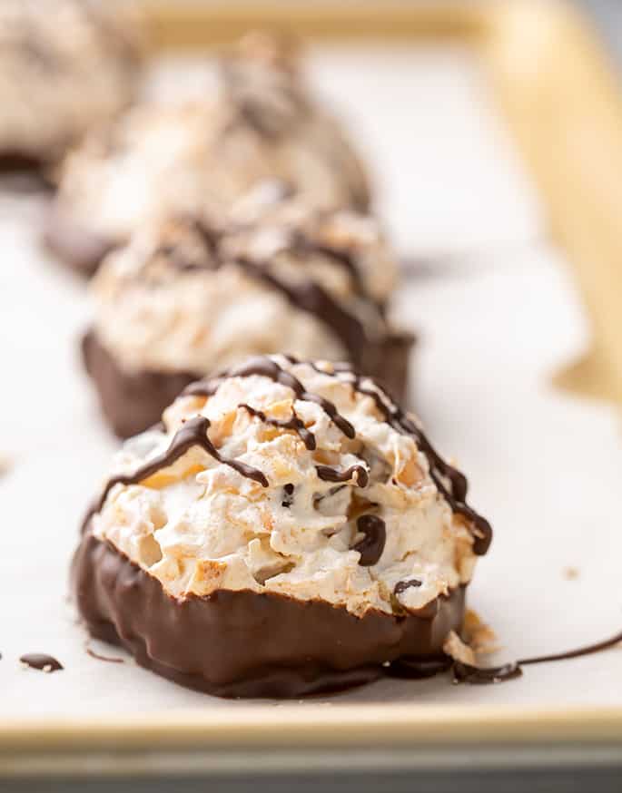 Coconut macaroons with bottoms dipped in chocolate on tray