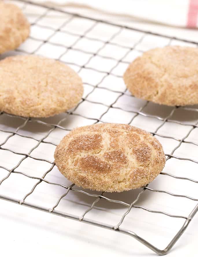 gluten free snickerdoodles on wire rack cooling over white cloth