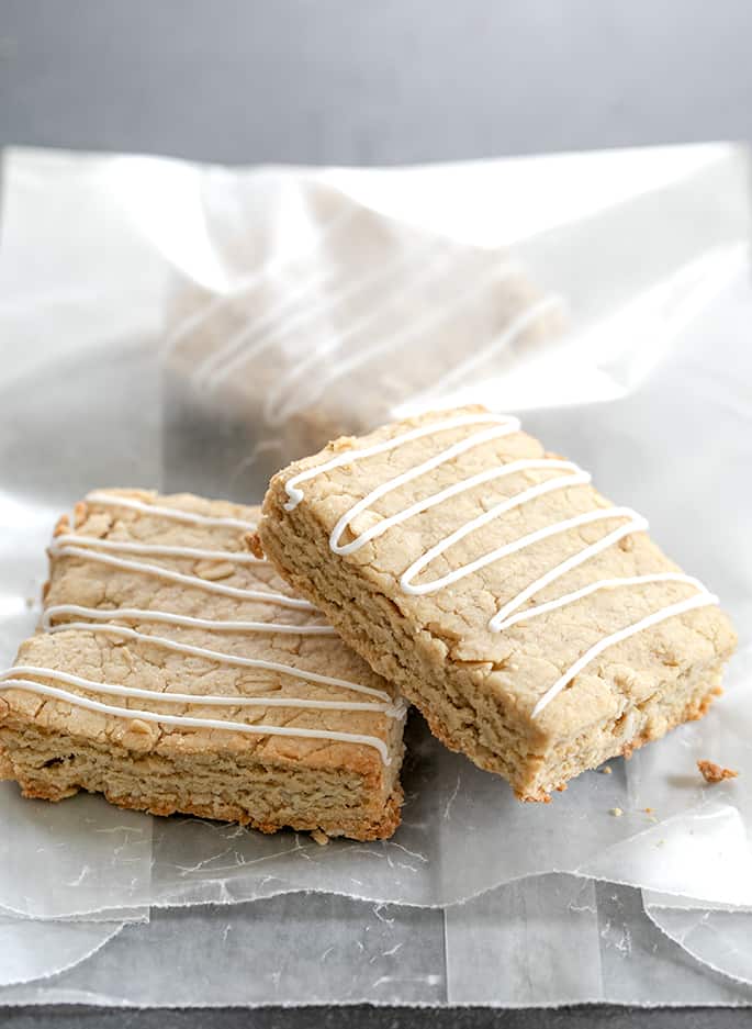 Oatmeal bars on a wax paper bag and inside the bag