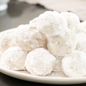 gluten free snowball cookies in a pile on a white plate