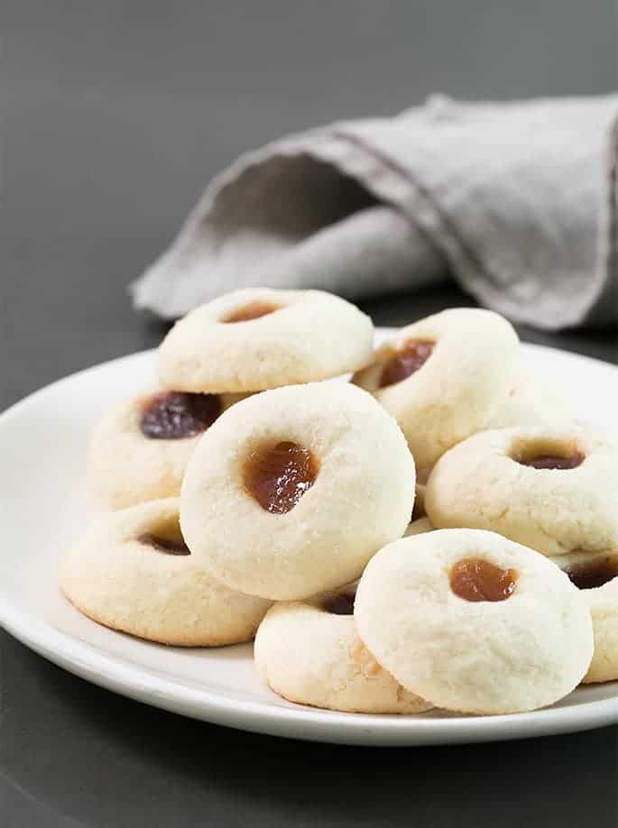 These easy gluten free thumbprint cookies are simple butter cookies made with flour, sugar, butter and egg yolks—and a dollop of jam on top. 