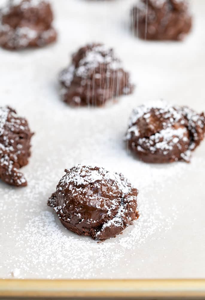 Confectioners' sugar falling onto raw chocolate cookies