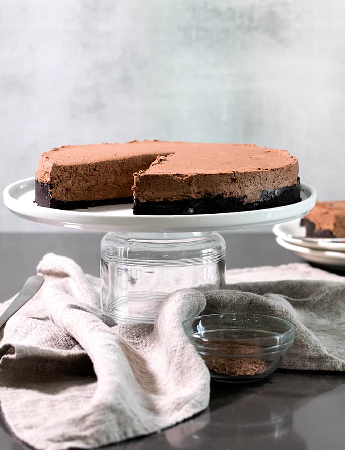 A cake sitting on top of a cake plate on a table