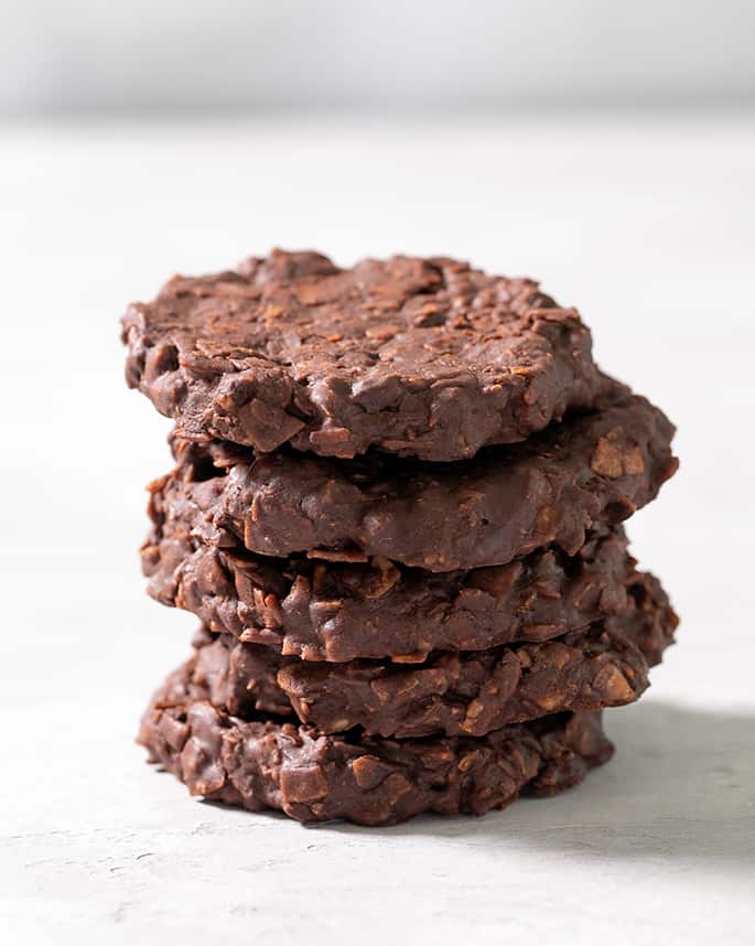 A stack of 5 brown cookies with made with coconut flakes as a substitute for oats