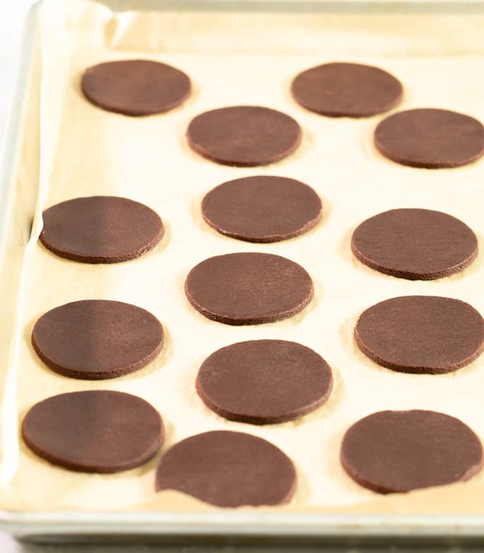 Raw cutouts of chocolate wafer cookies on a tray