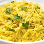 Small square closeup image from the side of rice a roni with fresh parsley in white round bowl