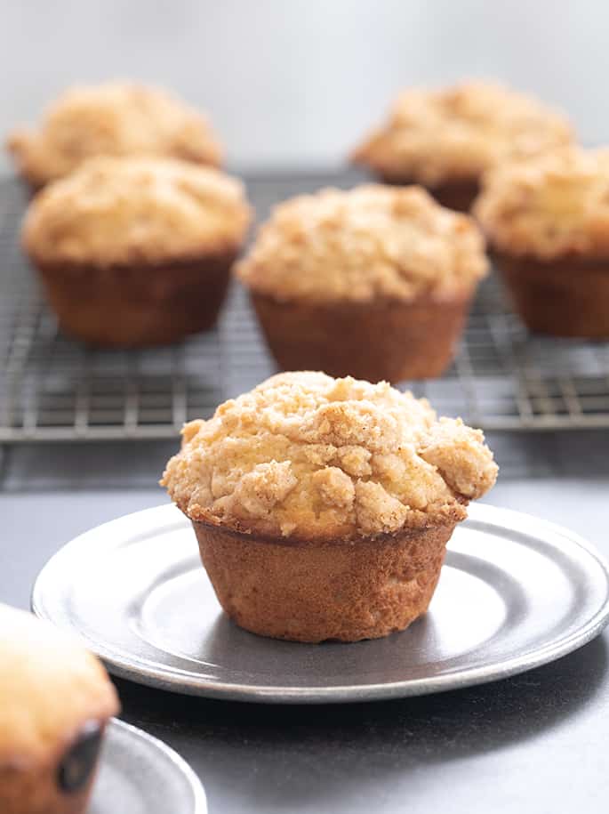 gluten free muffin with tan crumble topping on small round metal plate