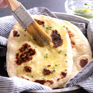 gluten free naan in striped towel with pastry brush