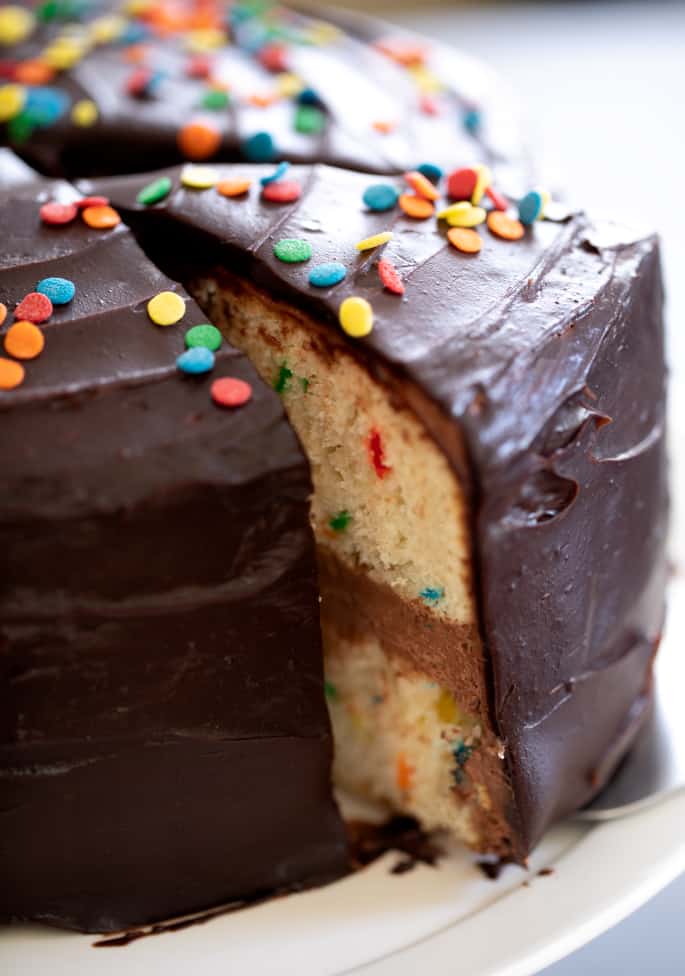 This classic gluten free birthday cake is a funfetti vanilla layer cake filled with chocolate sour cream frosting and topped with chocolate icing. It's your new go-to birthday cake.