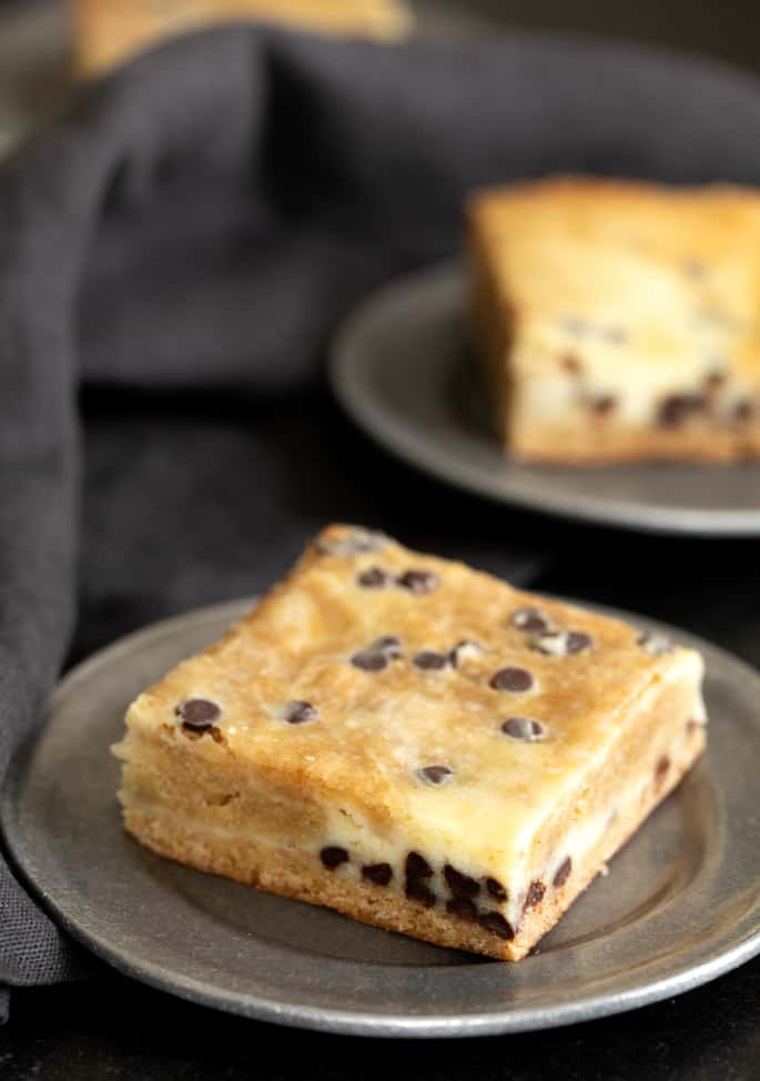 A chocolate chip cheesecake blondie on a small plate