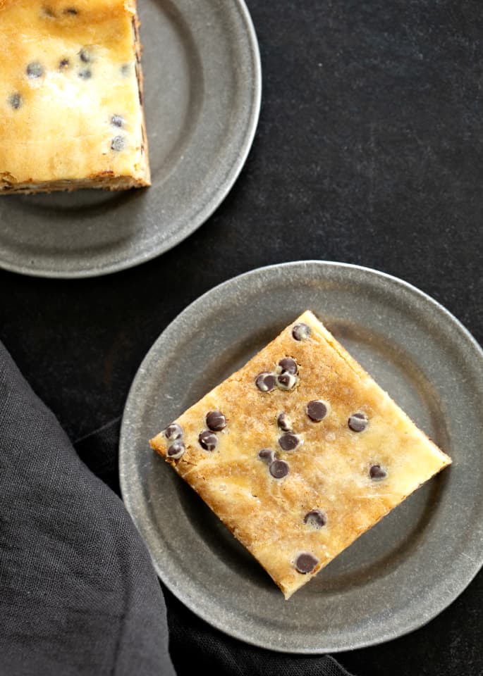 Overhead image of two chocolate chip cheesecake blondies on small plates