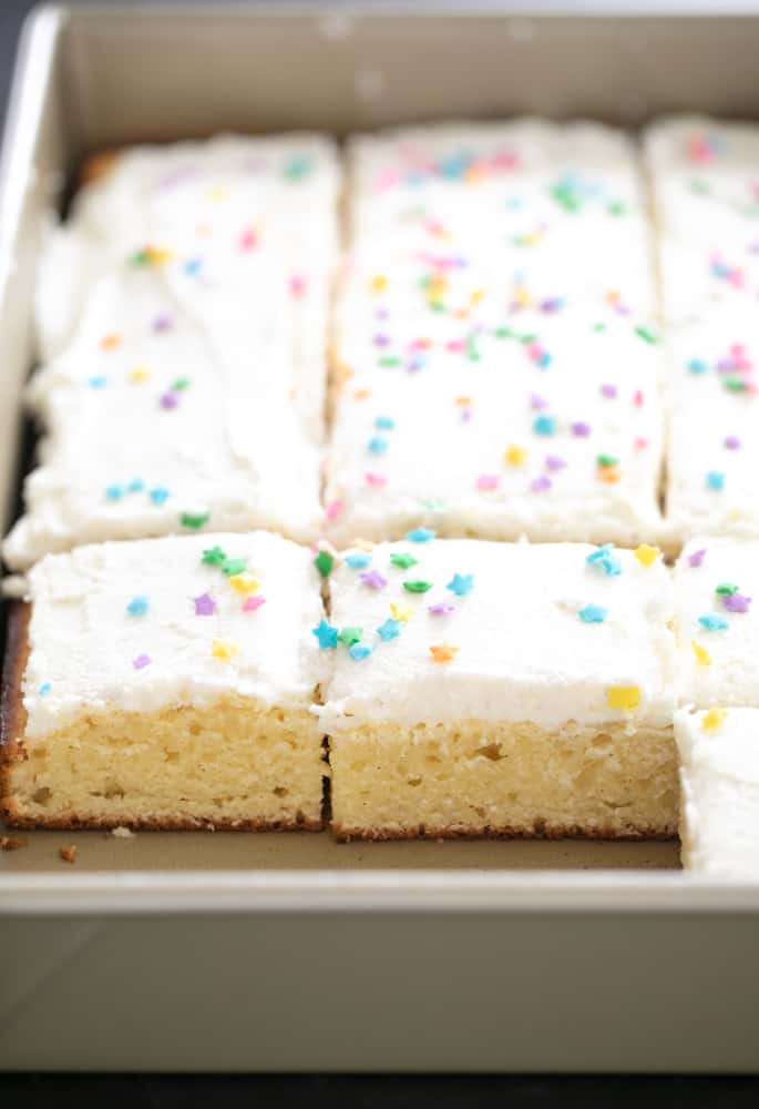 Vanilla sheet cake with frosting and edible stars in a pan