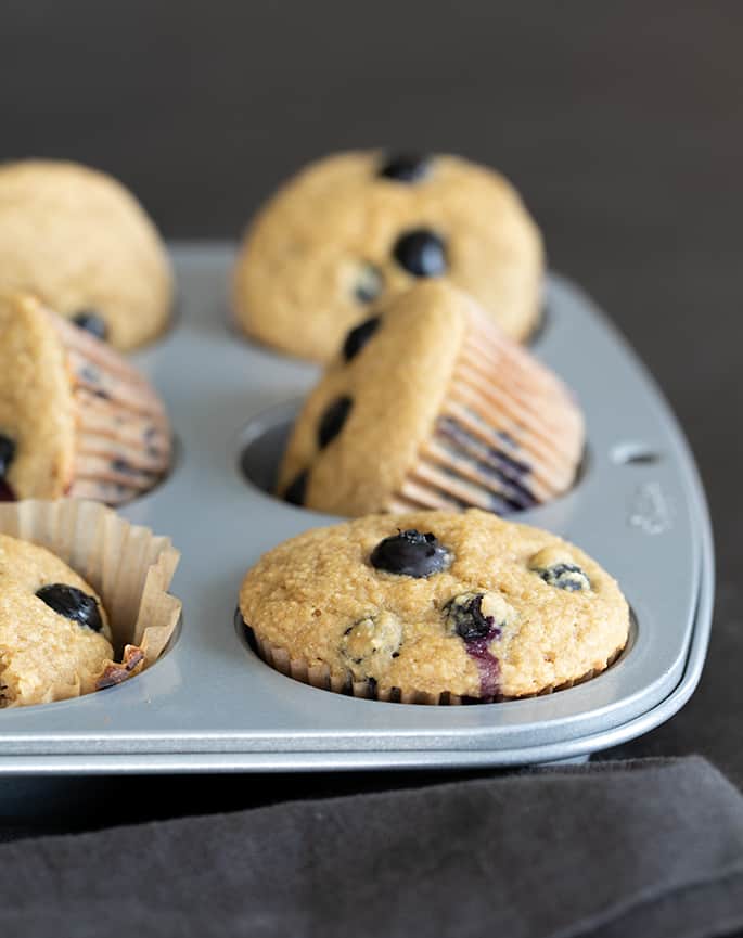 Image of a muffin tin with healthy blueberry muffins.