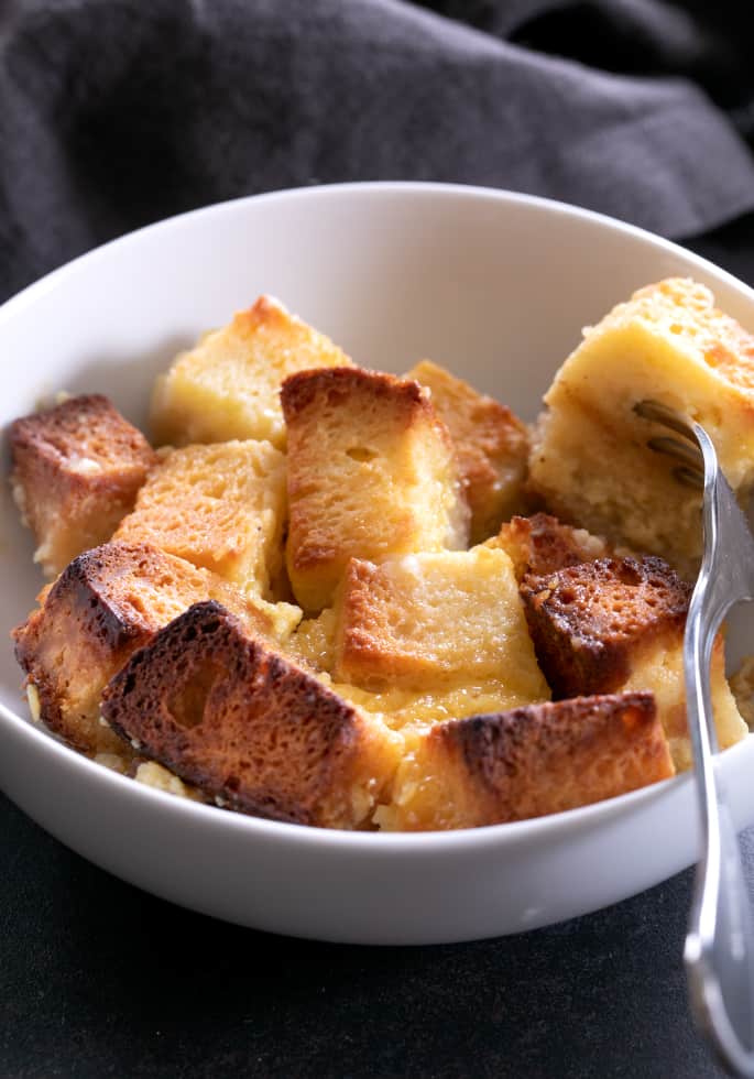 A bowl with a forkful of gluten free bread pudding.