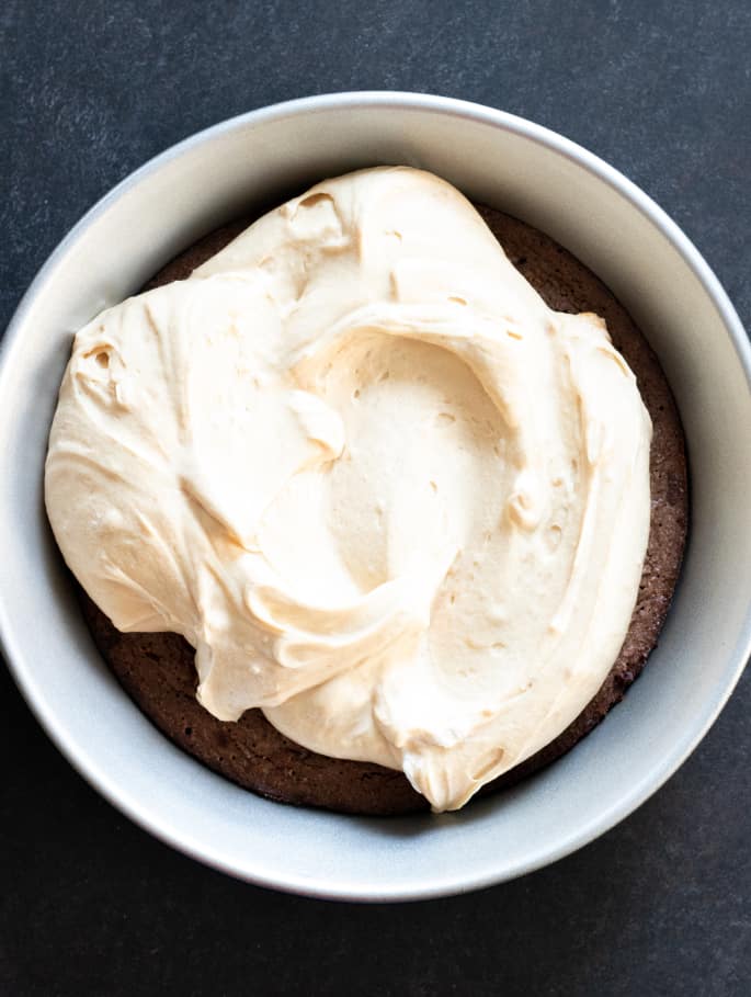 Peanut butter mousse filling on top of a brownie crust in a pie plate.