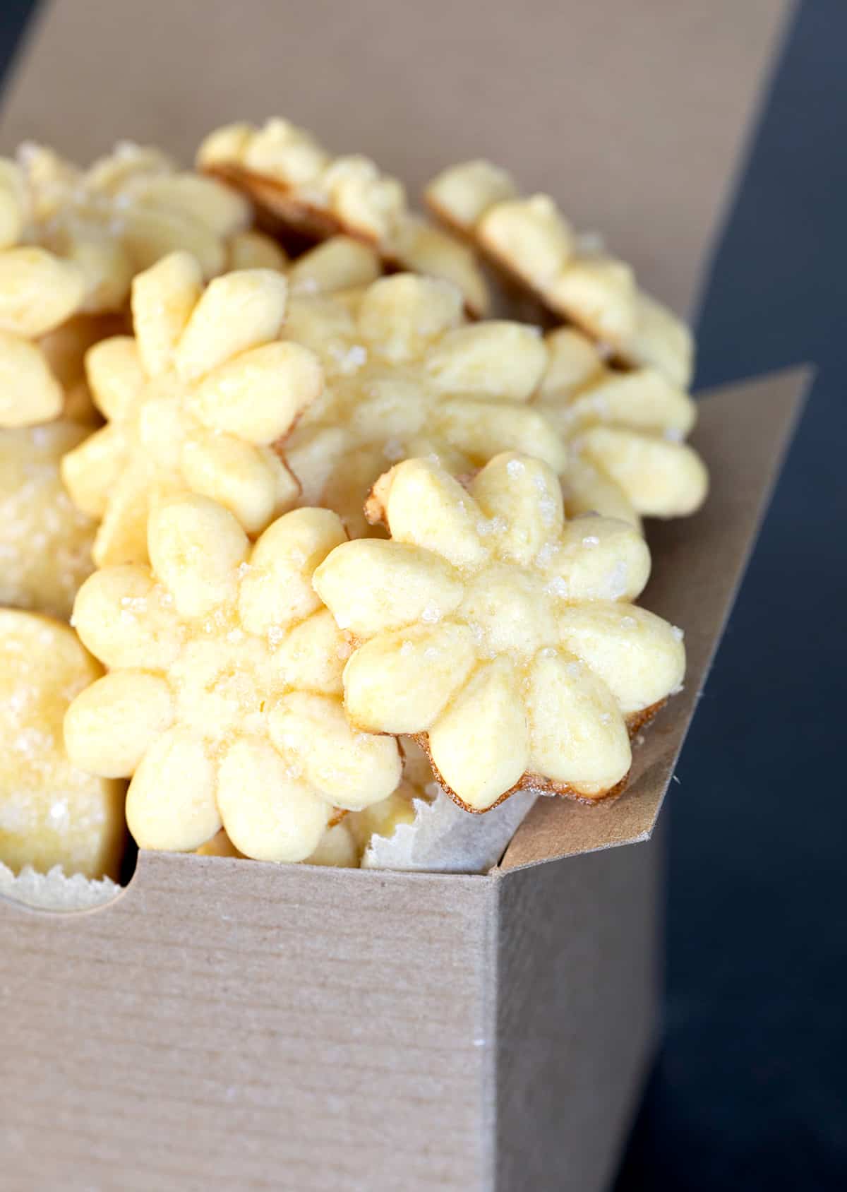 A close up of a box of gluten free butter cookies in a flower shape.