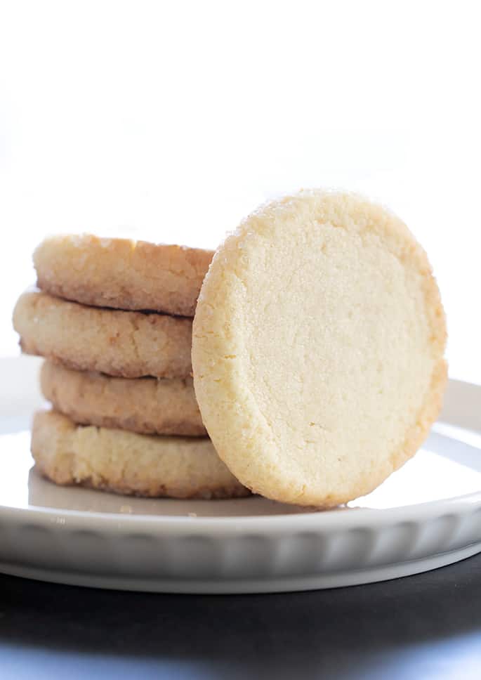 Stack of gluten free sable cookies with one cookie standing on its end.