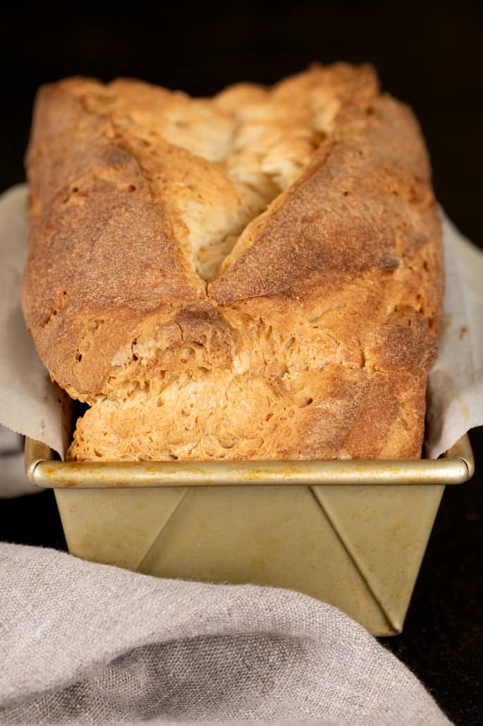 Tom's gluten free sandwich bread loaf shown in the loaf pan, just baked and mostly cool.