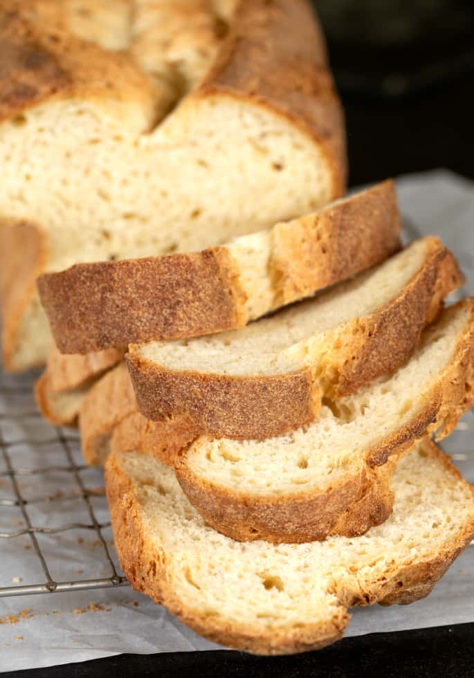 Tom's gluten free sandwich bread shown as it's being sliced. 