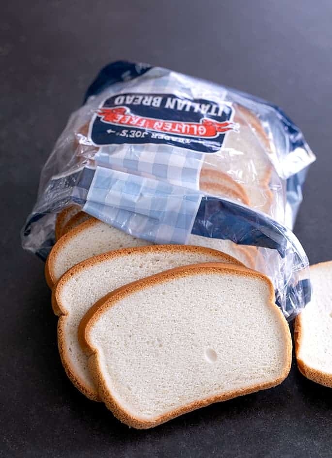 Slices of Trader Joe's brand baked Italian sandwich bread coming out of a plastic package of bread