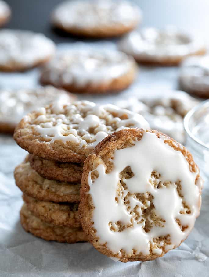 Short stack of gluten free iced oatmeal cookies, with one cookie facing forward.