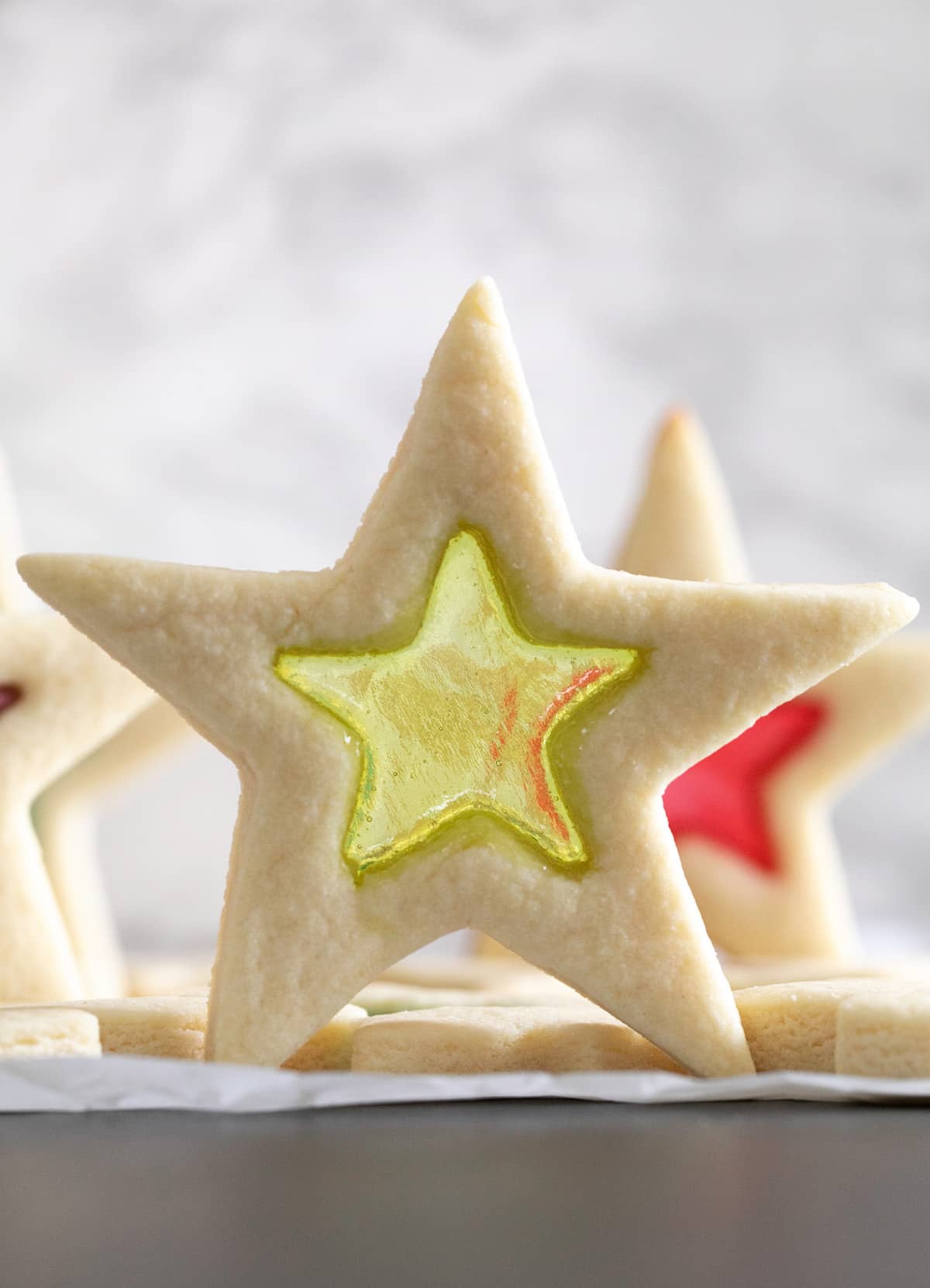 Stack of stained glass gluten free sugar cookies shaped like stars with one standing up