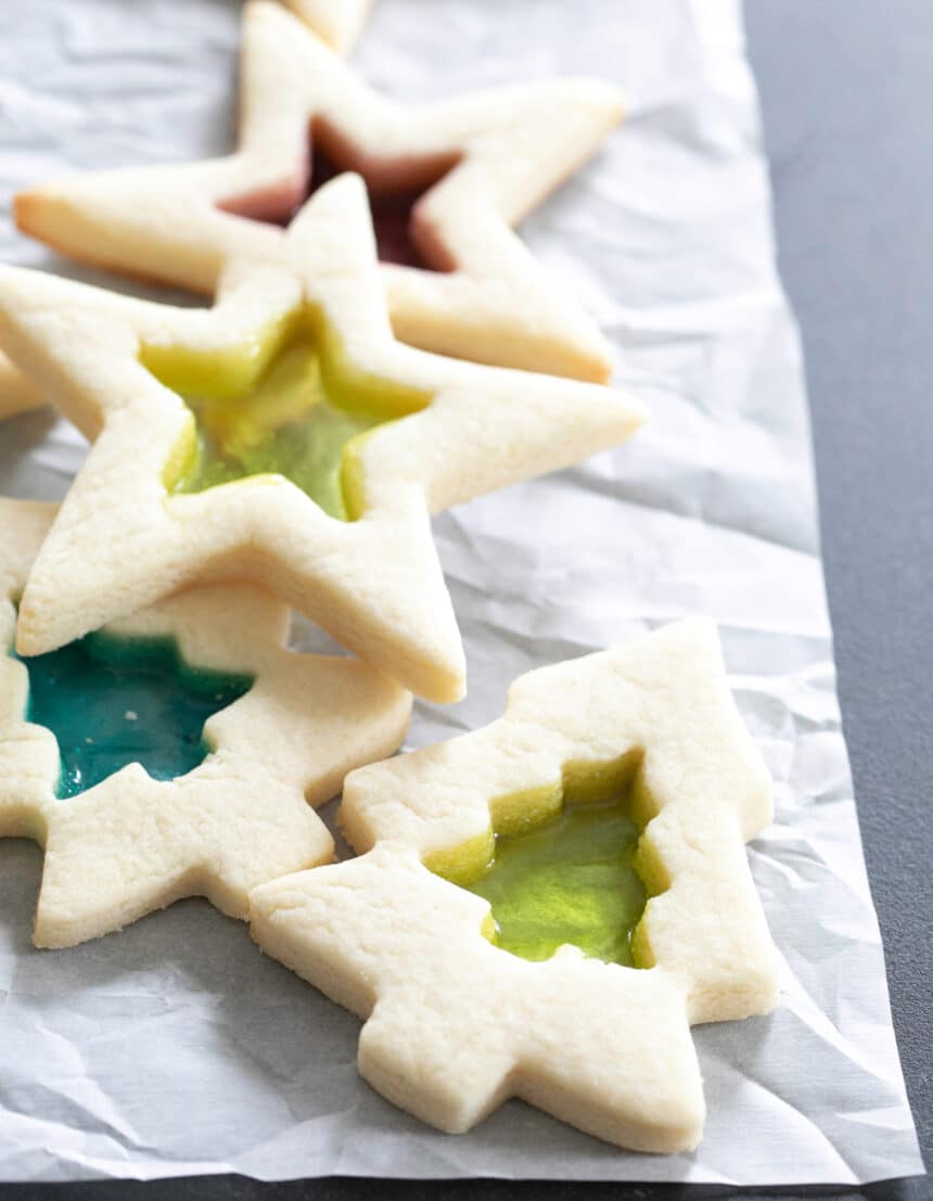 Image of pile of stained glass gluten free sugar cookies shaped like stars and Christmas trees