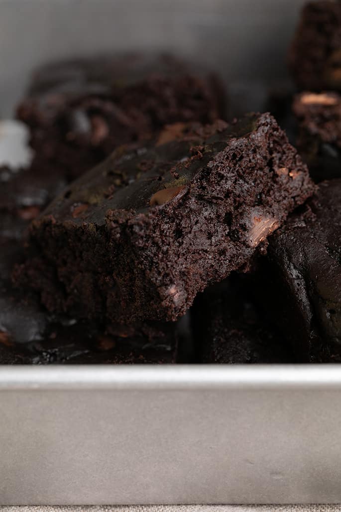 Black bean brownies in a pile in a metal baking pan