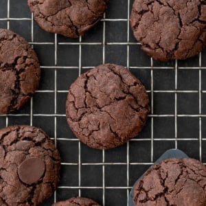 dark brown chocolate cookies spaced evenly apart cooling on wire metal rack