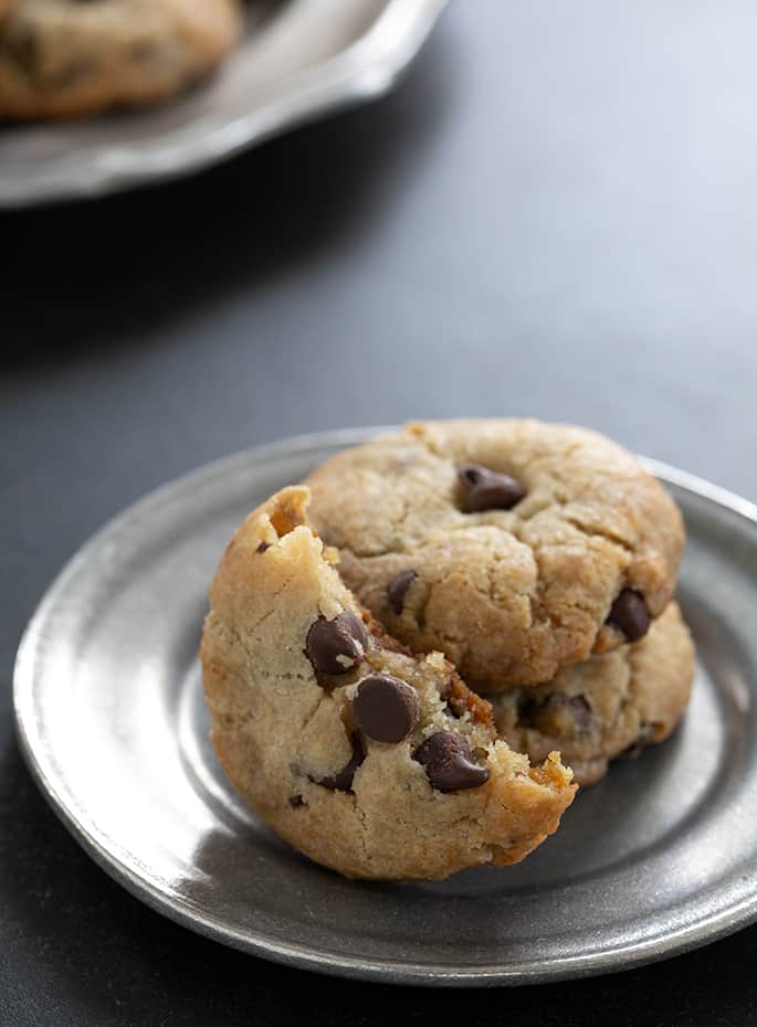 Vegan gluten free chocolate chip cookies with a view of the crisp edges and extra chewy inside.