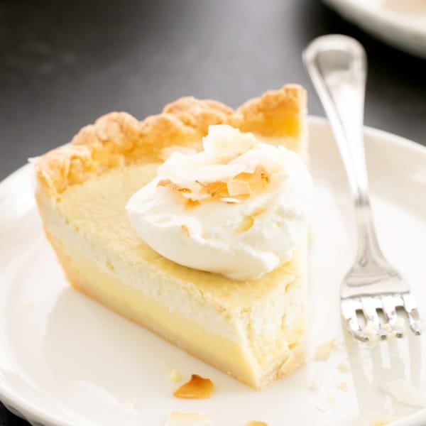 closeup image of slice of gluten free coconut cream pie with whipped cream and coconut pieces