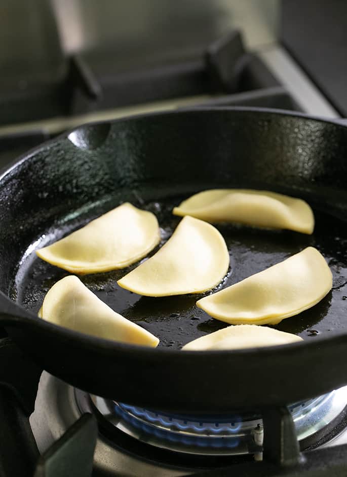 Potstickers cooking in a skillet