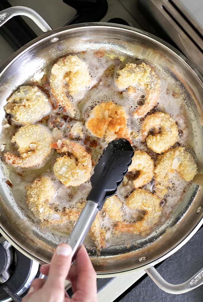 Coconut shrimp frying in a skillet