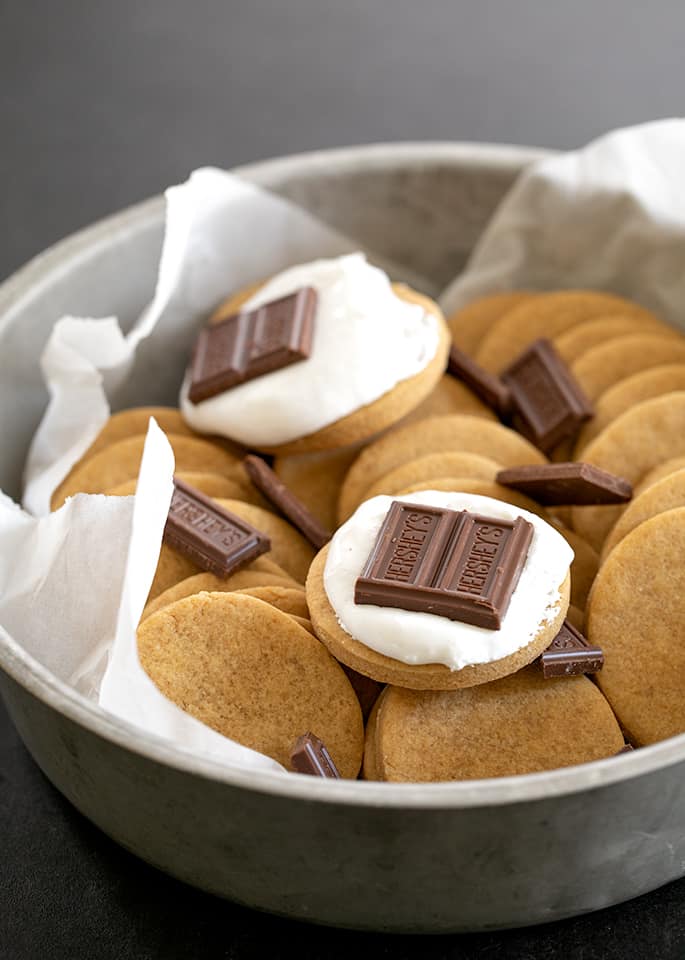 Round tin with graham cracker cookies with marshmallow fluff and chocolate