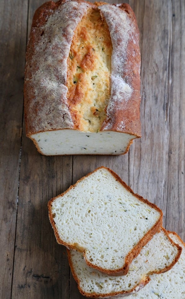 Overhead image of sliced gluten free zucchini yeast bread on a wooden table