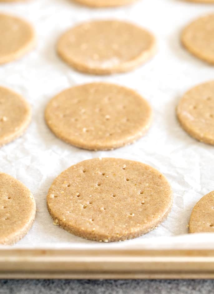 Raw shaped digestive biscuits on white paper on a tray