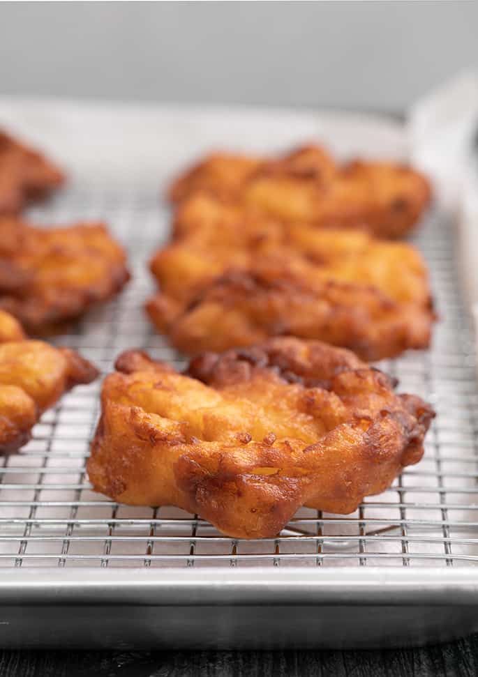 Apple fritters cooling on a wire rack