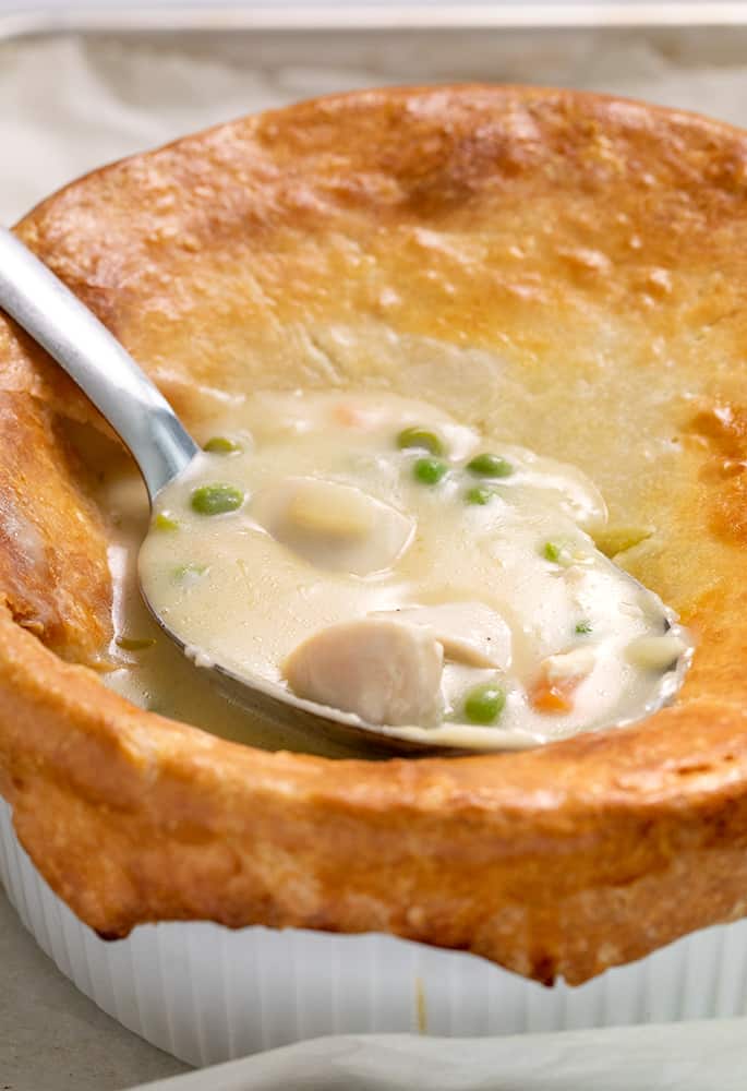 Chicken pot pie in casserole dish with serving spoon