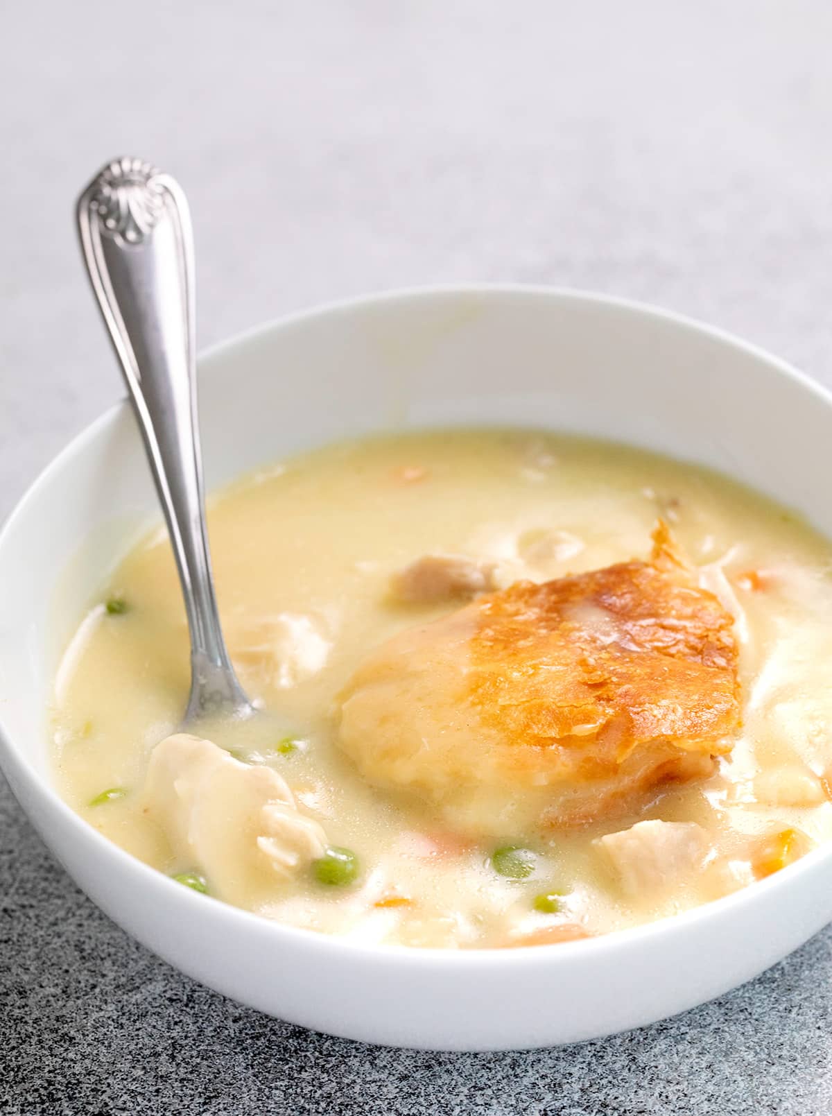 Chicken pot pie served in a small white bowl with a spoon