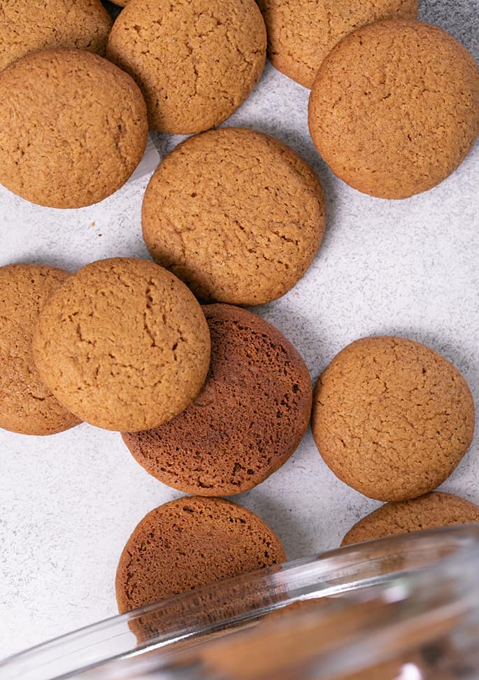 Gingersnaps falling out of glass jar overhead image