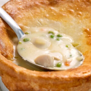 gluten free chicken pot pie in serving spoon on top of baked crust