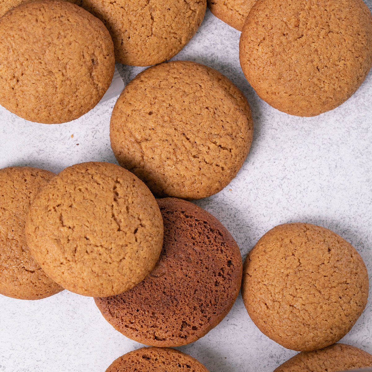 scattered gluten free gingersnaps cookies on white surface