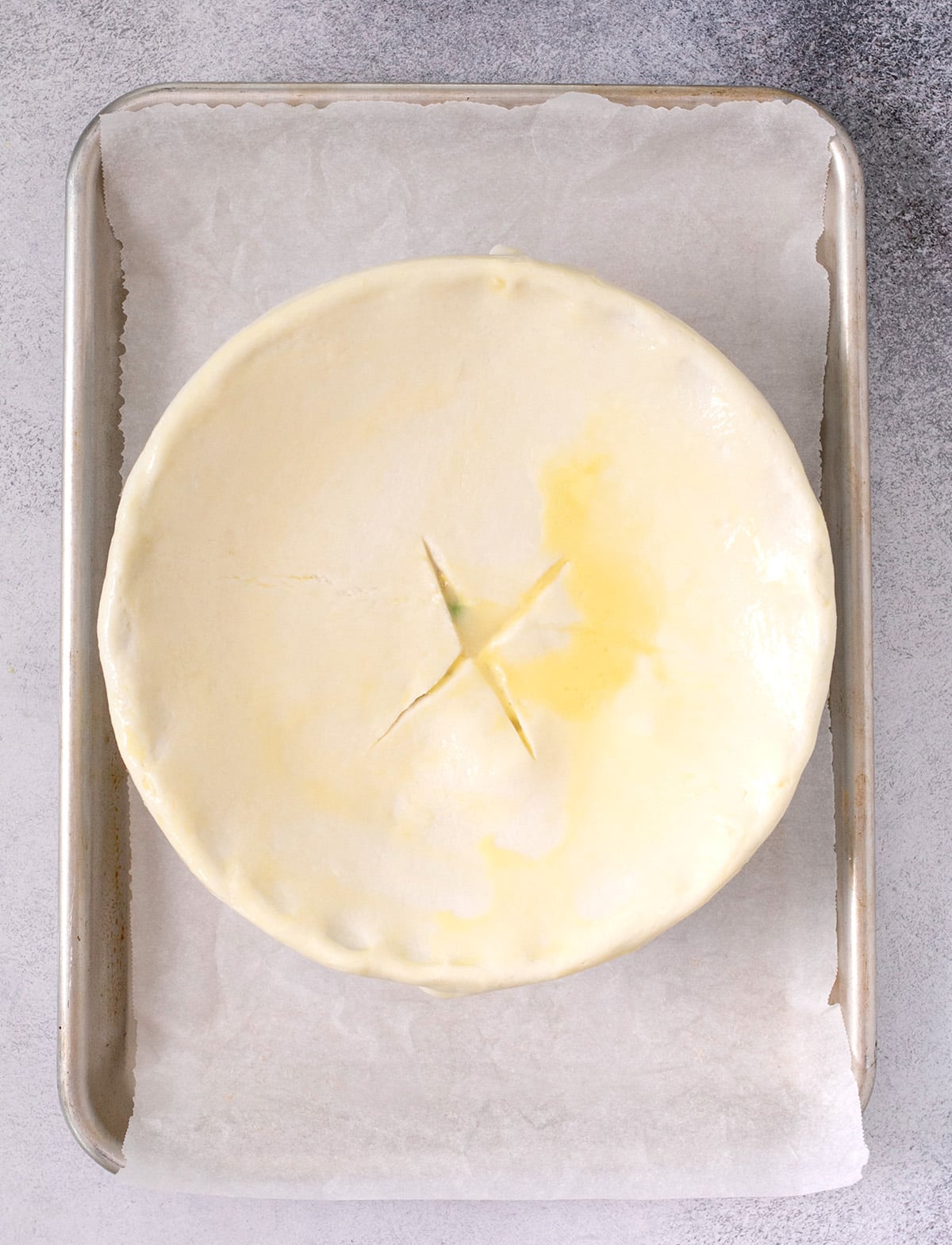Overhead image of pie crust covering round casserole dish