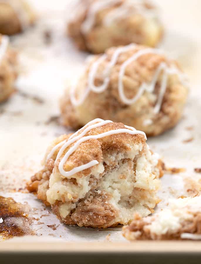 baked cinnamon sugar drop biscuit broken in half on white paper