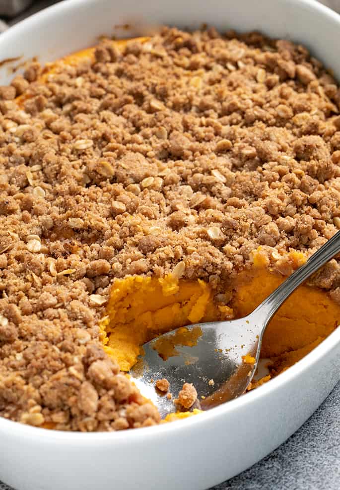 Sweet potato casserole dish with serving spoon closeup image